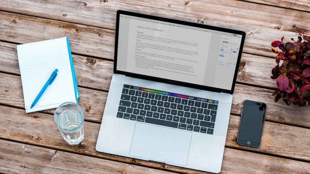 Printed resume beside a laptop on a desk