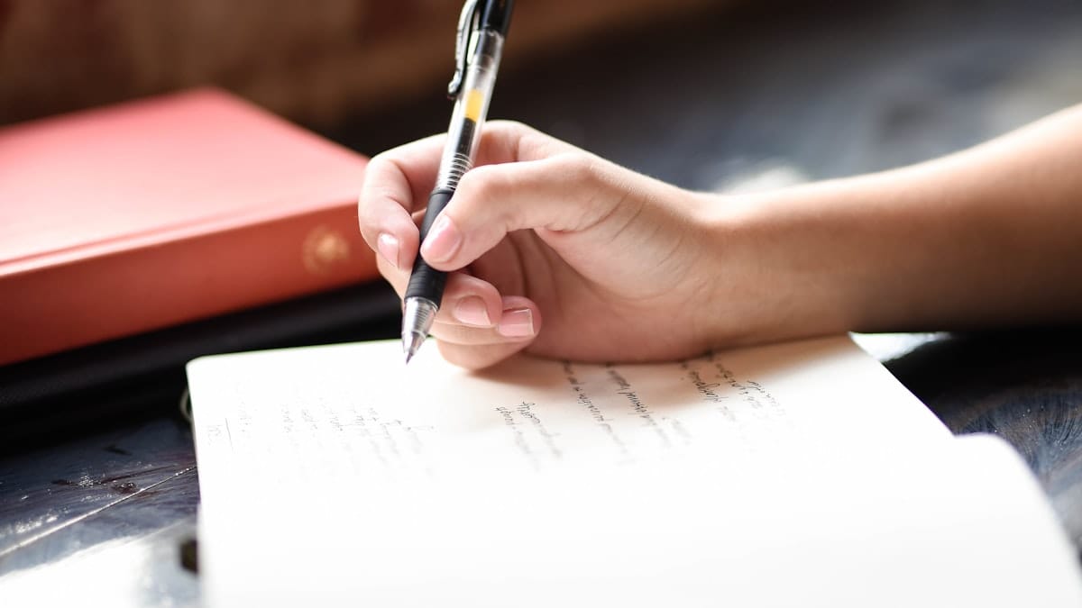 Hand writing a cover letter on paper