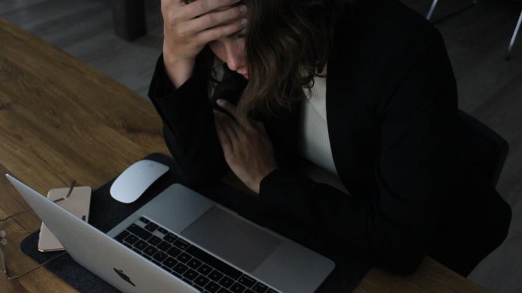 Office worker sitting with head in hands
