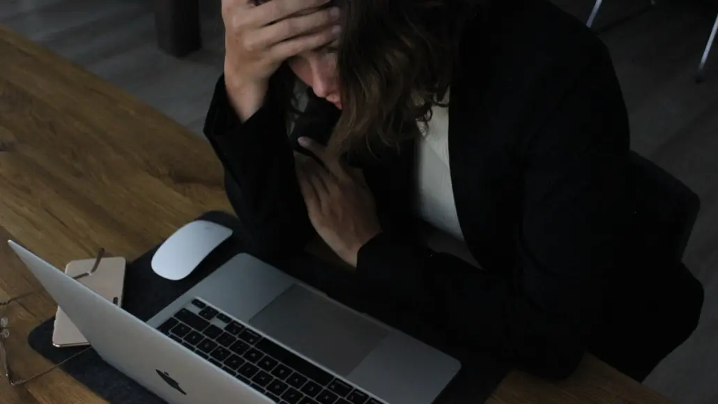 Office worker sitting with head in hands