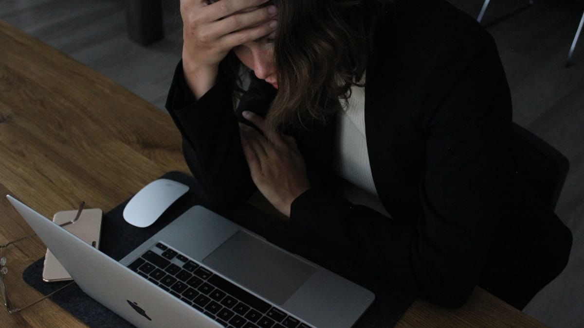 Stressed office worker with head in hands