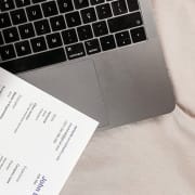Resume beside laptop and coffee on desk