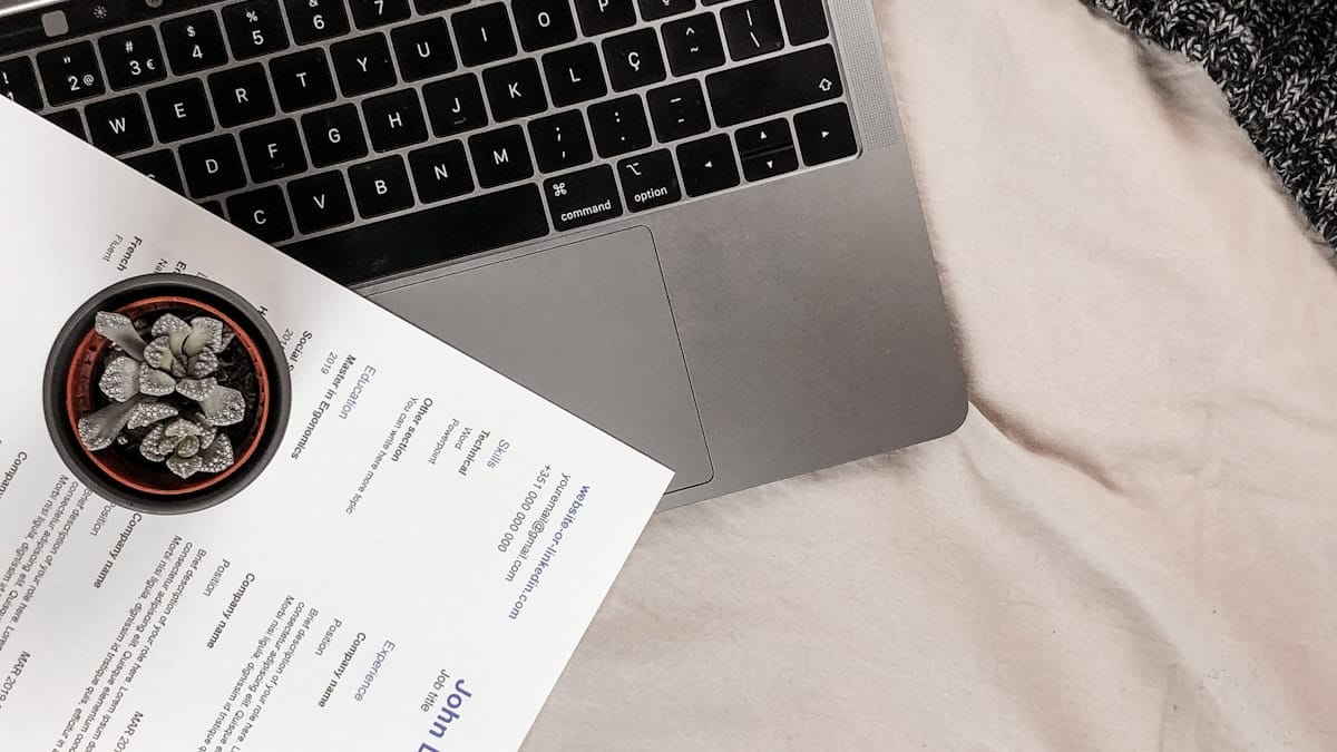 Resume beside laptop and coffee on desk