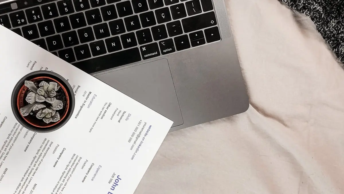 Resume beside laptop and coffee on desk